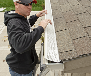 Technician installing a gutter guard on a home's gutter system.