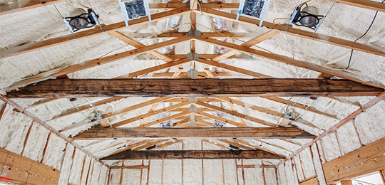 Spray foam insulation in ceiling of an unfinished building.