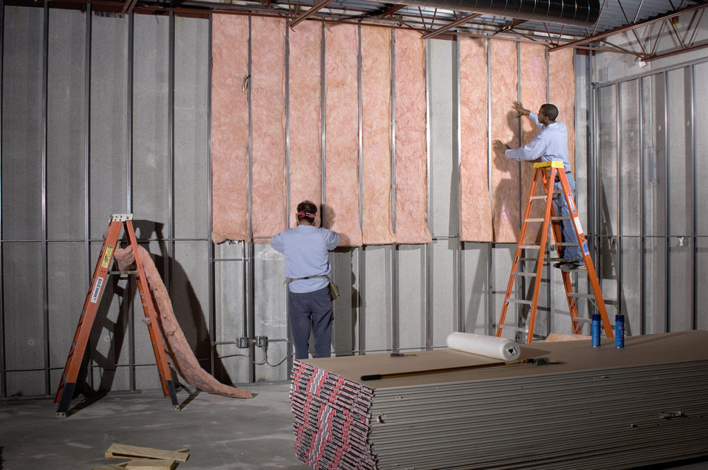 Insulation being installed by technicians in a warehouse in Tulsa